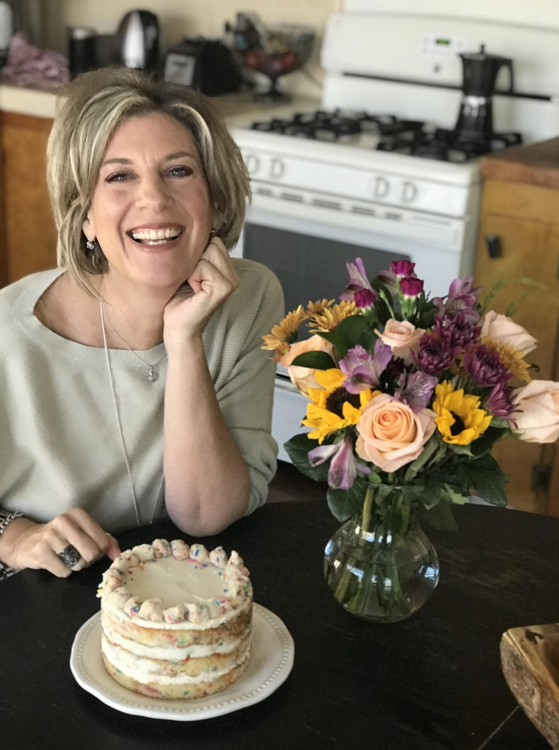 Stacey smiling by a birthday cake
